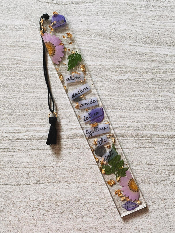 A mix of leaves, purple & black flowers with gold foil flakes.